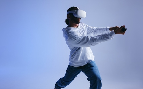 Young man playing cricket in virtual reality