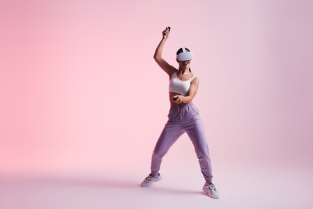 Female gamer dancing and having fun in virtual reality