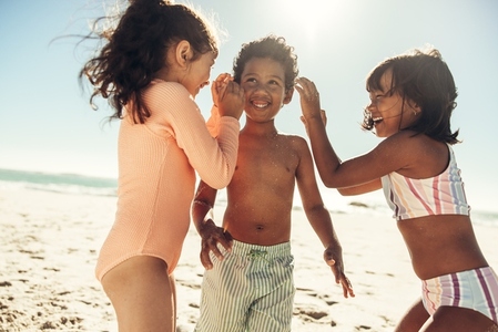 Cheerful little kids playing together at the beach