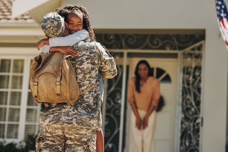 Army soldier embracing his daughter after returning home