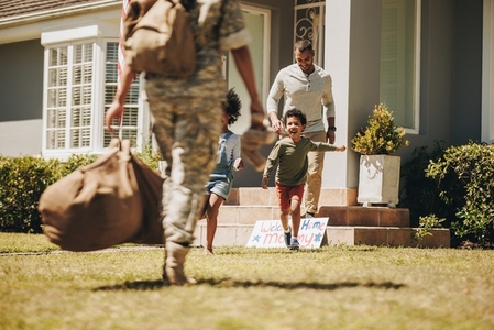 Female soldier being welcomed by her family at home
