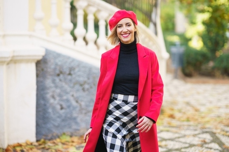 Smiling woman in stylish outfit walking on street