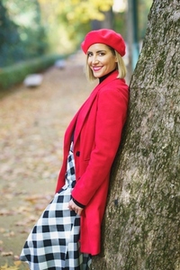 Charming woman standing near tree trunk in park