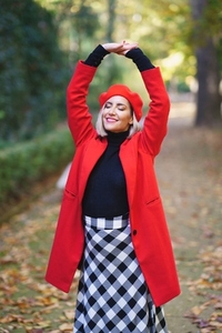 Joyful woman with raised arms in park