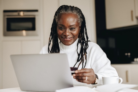 Happy mature woman shopping online with a credit card
