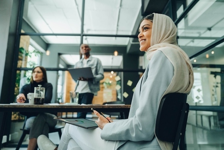 Happy Muslim businesswoman sitting in an office meeting