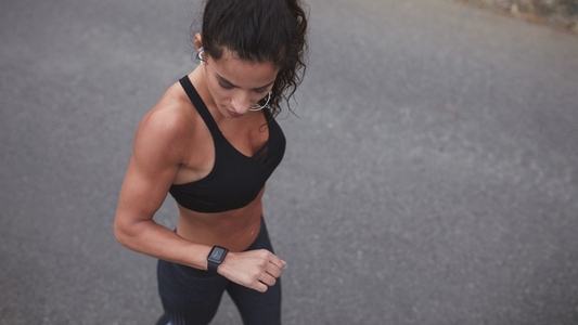 Female athlete checking her smartwatch after a run
