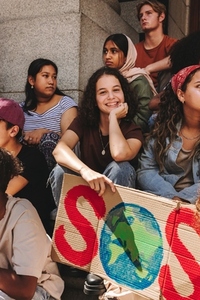 Happy teenage girl protesting against climate change with a group of activists