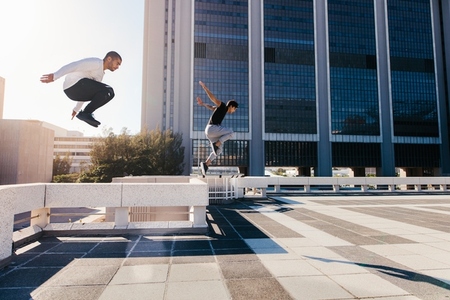 Two sportsmen doing parkour in city
