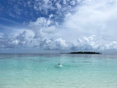 Woman swims in a clear tropical ocean