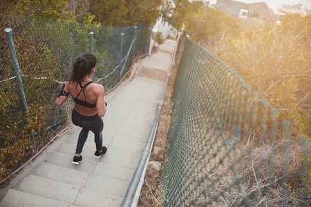 Athletic young woman running down the stairs