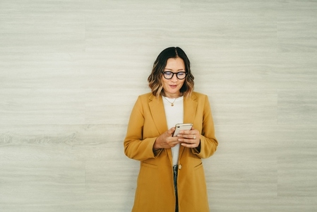 Cheerful businesswoman reading a text message in an office
