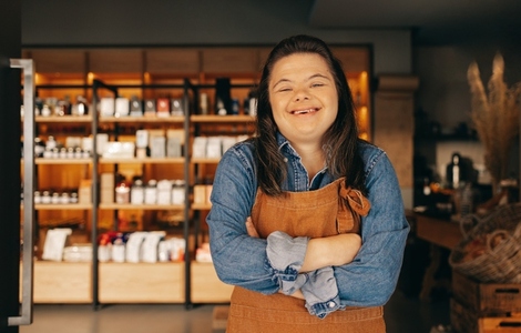 Happy woman with Down syndrome standing in front of a store