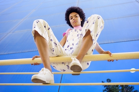 Black woman sitting on railing in city