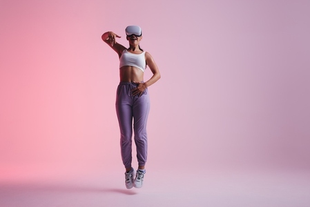 Energetic young woman dancing in virtual reality