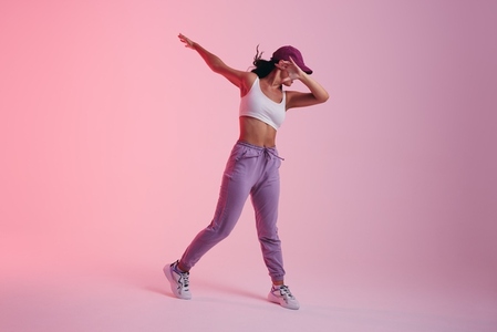 Young woman doing the dab dance move in a studio