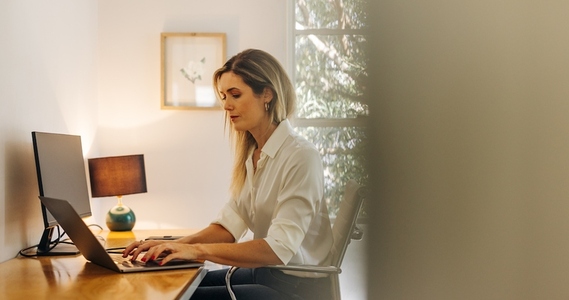 Businesswoman typing on a laptop in her home office