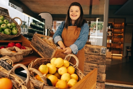 Happy woman with Down syndrome working in a grocery store