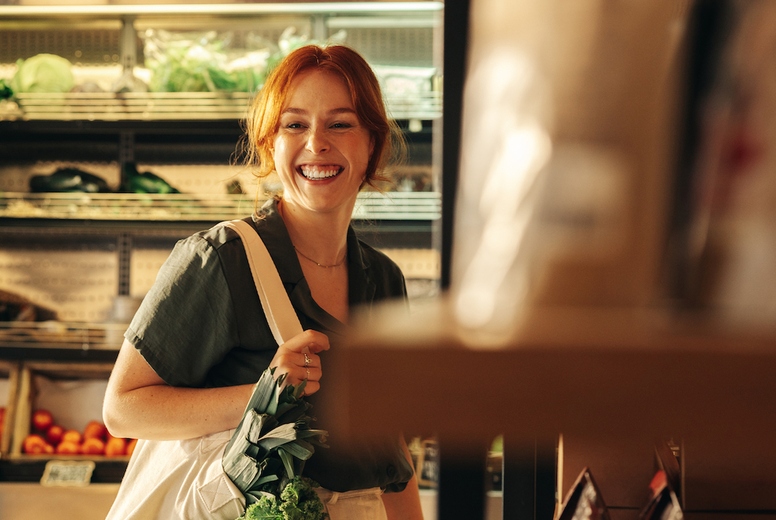 Cheerful young woman grocery shopping in a supermarket
