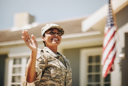 Cheerful female soldier waving her hand on her homecoming