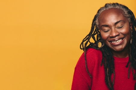 Black woman with dreadlocks smiling with her eyes closed