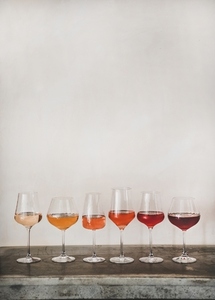 Various shades of Rose wine in stemmed glasses in line