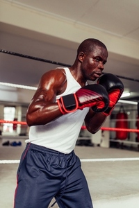 Young male boxer training in a fitness gym
