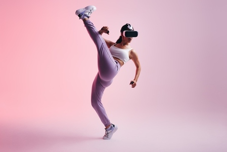Female gamer throwing a kick in a virtual reality game