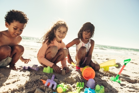 Group of kids playing with toys at the beach