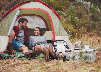 Loving young couple sitting in a camping tent