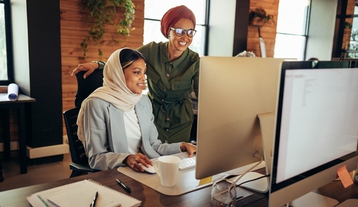 Two Muslim businesswomen working together in a coworking office