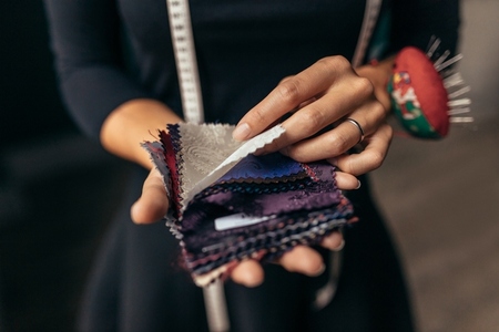 Female tailor holding fabric swatches