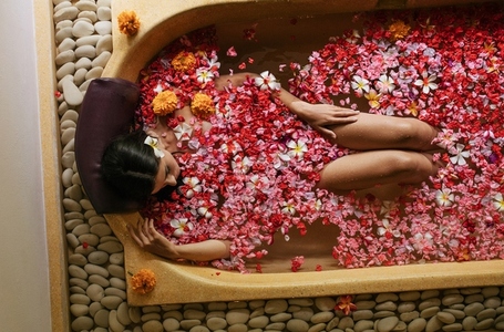 Woman in bathtub with petals