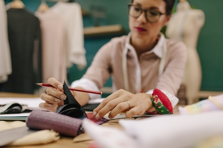 Female dressmaker choosing fabric from swatch