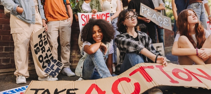 Cheerful teenage girl sitting with a group of youth peace activists