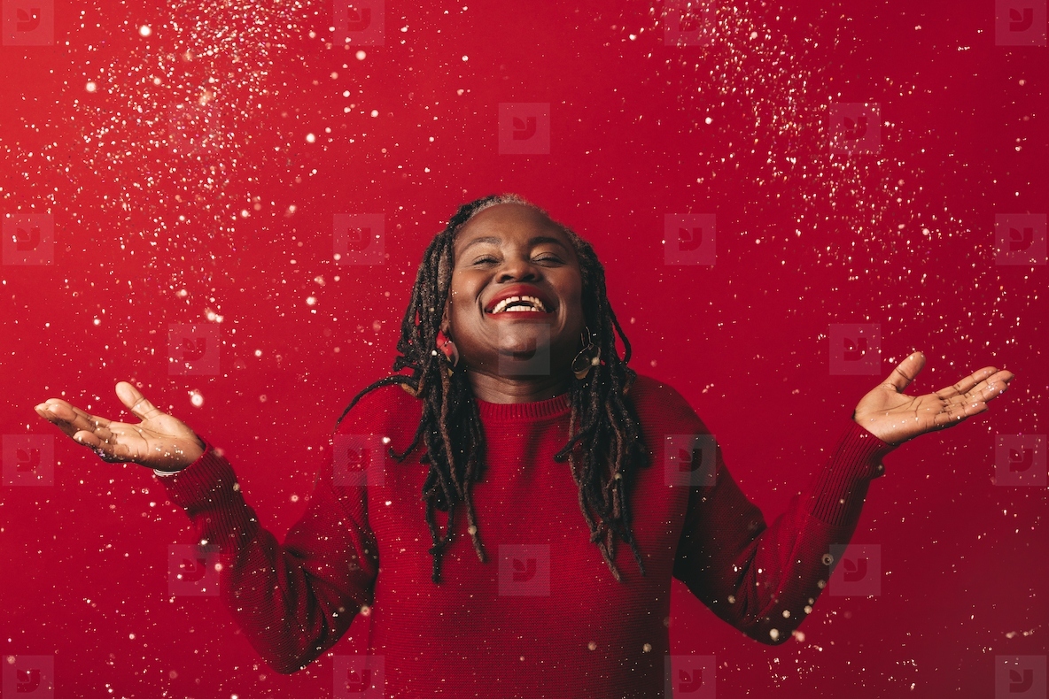 Joyful mature woman celebrating with confetti
