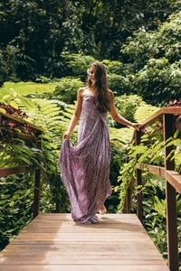 Attractive woman in a dress walking on small bridge