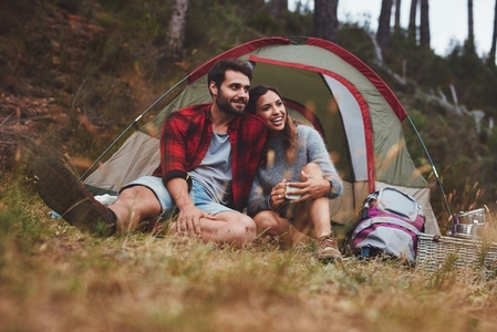Happy young couple enjoying themselves at a campsite