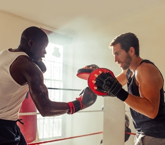 Boxer practicing uppercut punches with a personal trainer