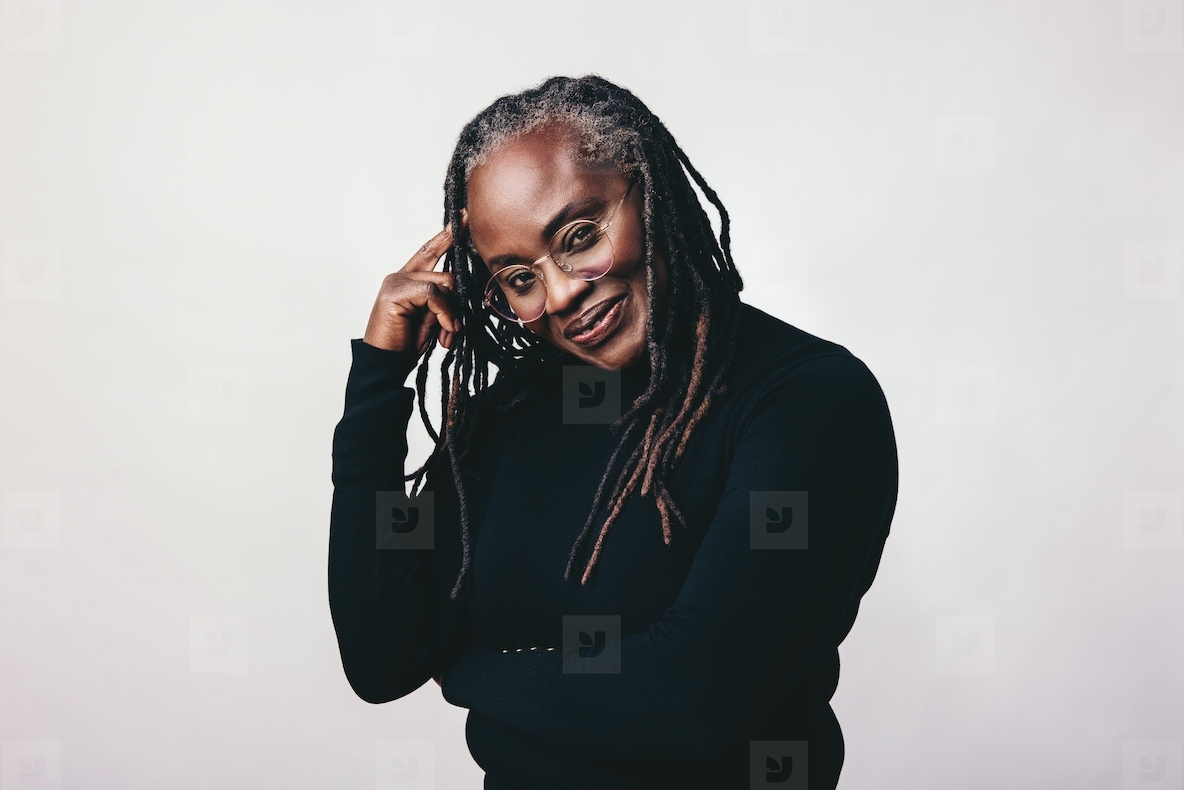 Middle aged woman with dreadlocks looking at the camera in a studio