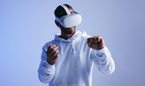 Cheerful young man having an immersive virtual reality experience