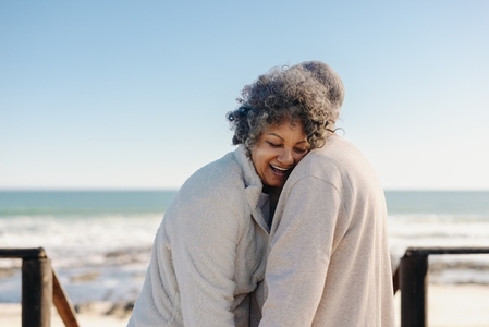 Happy senior woman laughing while leaning on her husband