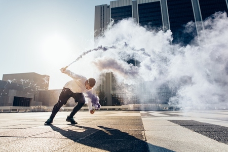 Man practicing free running with a smoke grenade