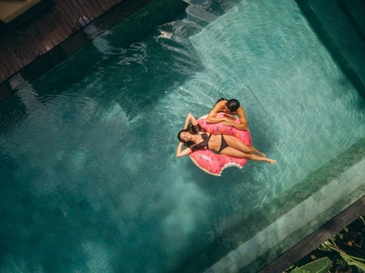 Couple relaxing on donut floatie in resort pool