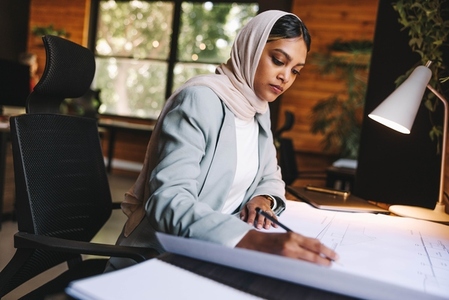 Innovative Muslim designer working with drawings in an office