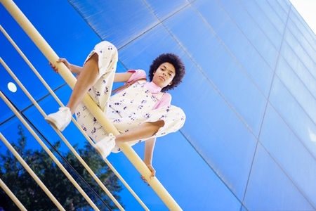 Serious black woman sitting on railing