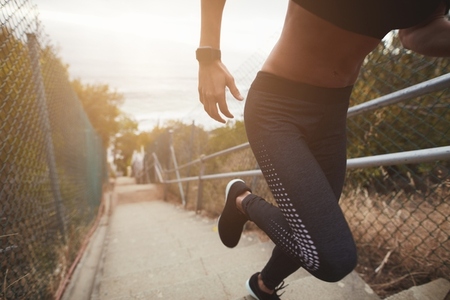 Female runner running up the stairs outdoors