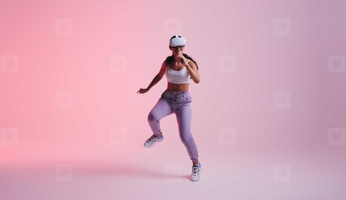 Cheerful young woman dancing in virtual reality