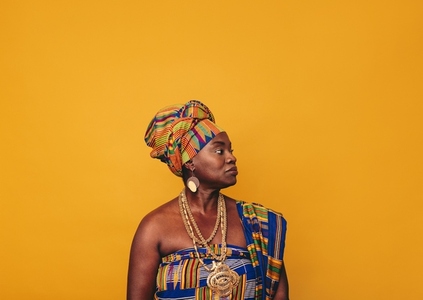African woman wearing elegant cultural clothing in a studio