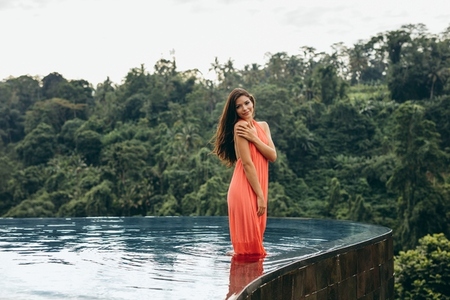 Beautiful young female model posing in swimming pool